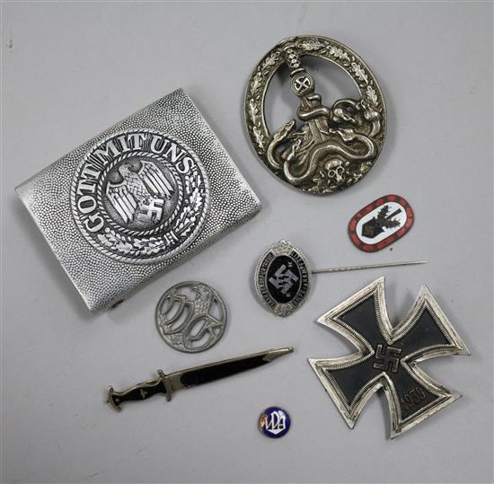 A German Iron Cross 1st class, an SS lapel badge number 792, dagger lapel pin, German army belt buckle, three German badges without pin